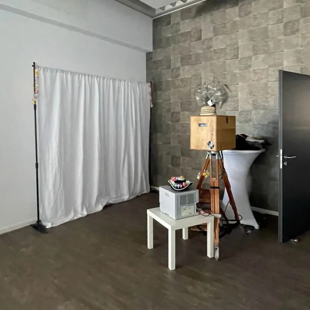 Photobooth-Aufbau mit weißem Hintergrund und Sofortdrucker für die Hochzeitsfeier
